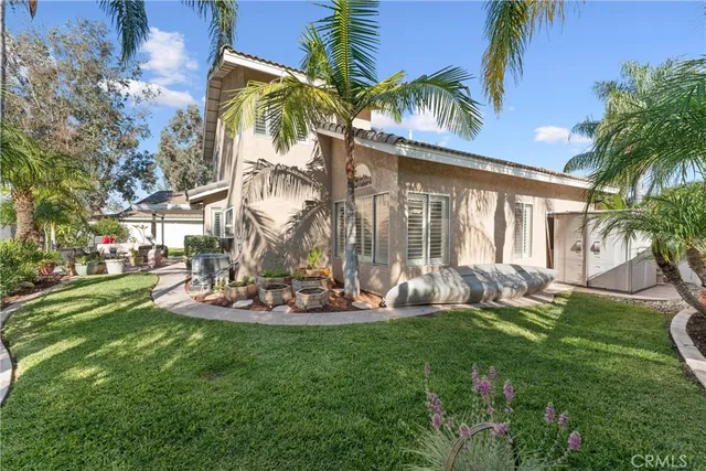 a front view of a house with garden and trees