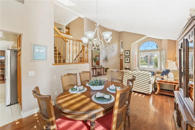 a view of a dining room with furniture a chandelier and wooden floor