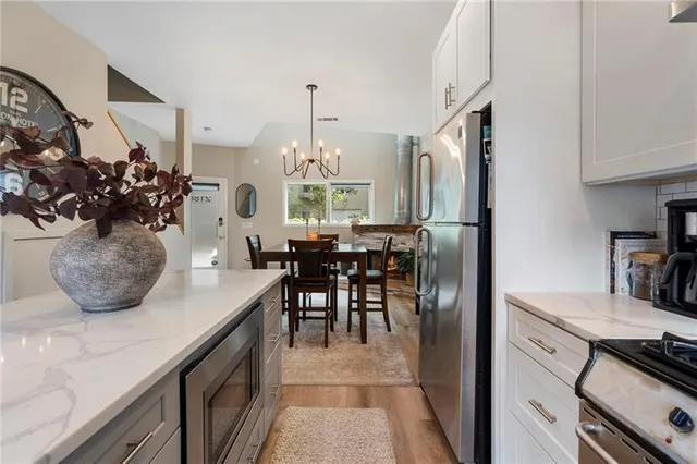 a kitchen with stainless steel appliances granite countertop a sink a stove and a refrigerator