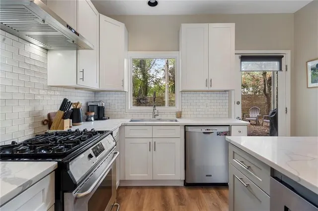a kitchen with granite countertop a sink stove and cabinets