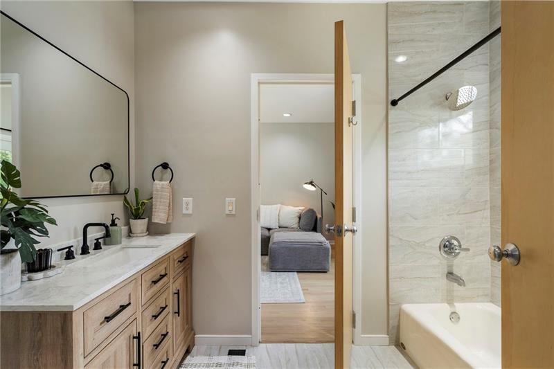 2188 Millennium Way Brookhaven, GA 30319 - Photo 28 of 52 a bathroom with a granite countertop sink a mirror a bathtub and shower