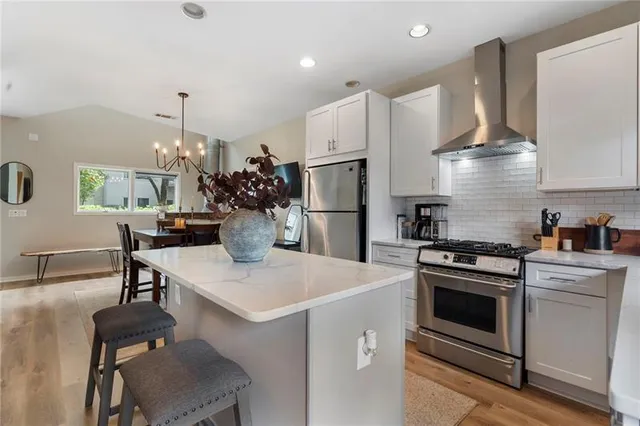 a kitchen with a stove a refrigerator and a fireplace