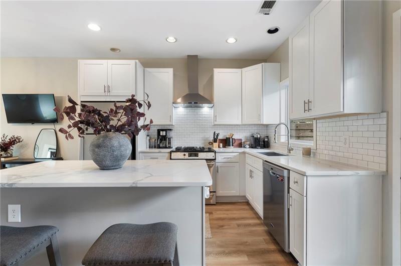 2188 Millennium Way Brookhaven, GA 30319 - Photo 10 of 52 a kitchen with a sink dishwasher a stove a microwave oven and white cabinets