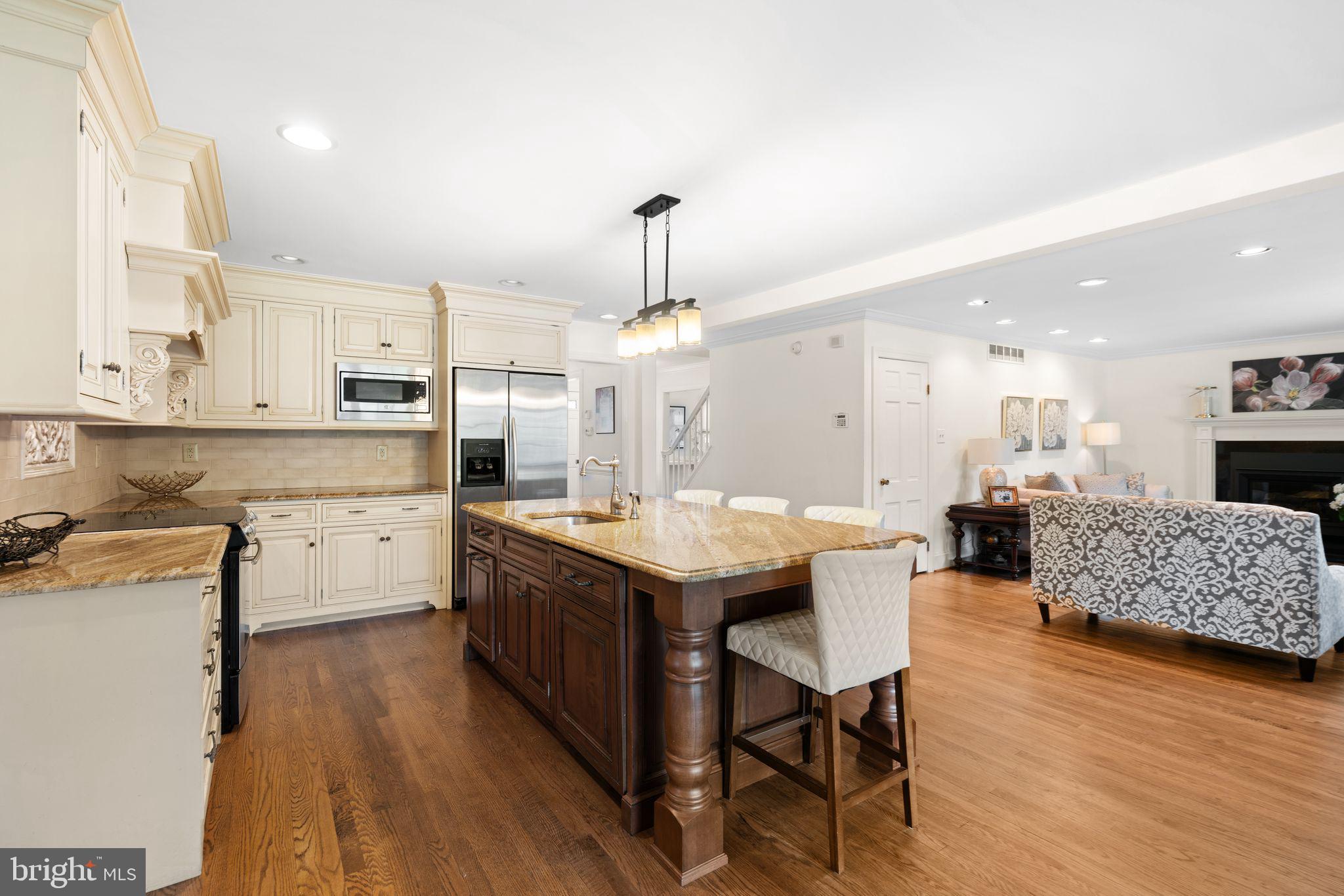 320 Warwick Road Haddonfield, NJ 08033 - Photo 8 of 41 a kitchen with stainless steel appliances kitchen island granite countertop a stove a sink a refrigerator and white cabinets with wooden floor