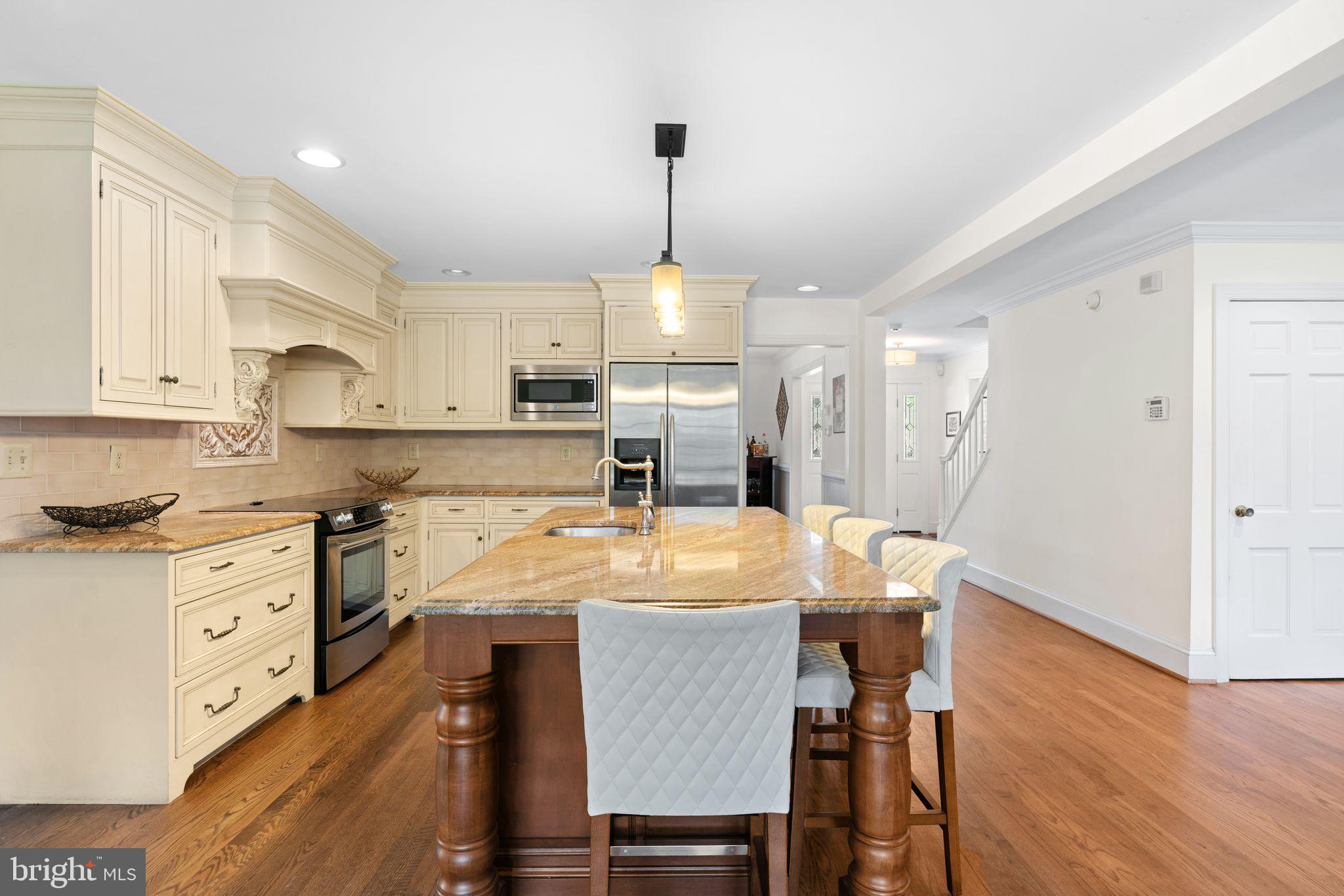 320 Warwick Road Haddonfield, NJ 08033 - Photo 10 of 41 a kitchen with stainless steel appliances granite countertop a stove top oven a refrigerator a sink and white cabinets with wooden floor