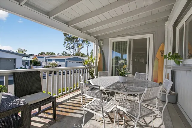 a view of a patio with table and chairs with wooden floor and fence