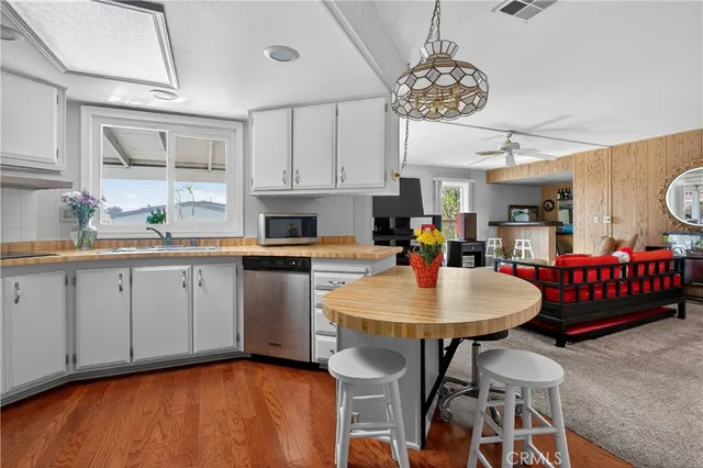 a open kitchen with stainless steel appliances granite countertop a kitchen island a stove a table and chairs in it