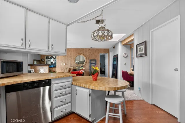 a kitchen with stainless steel appliances kitchen island granite countertop a table chairs and a refrigerator
