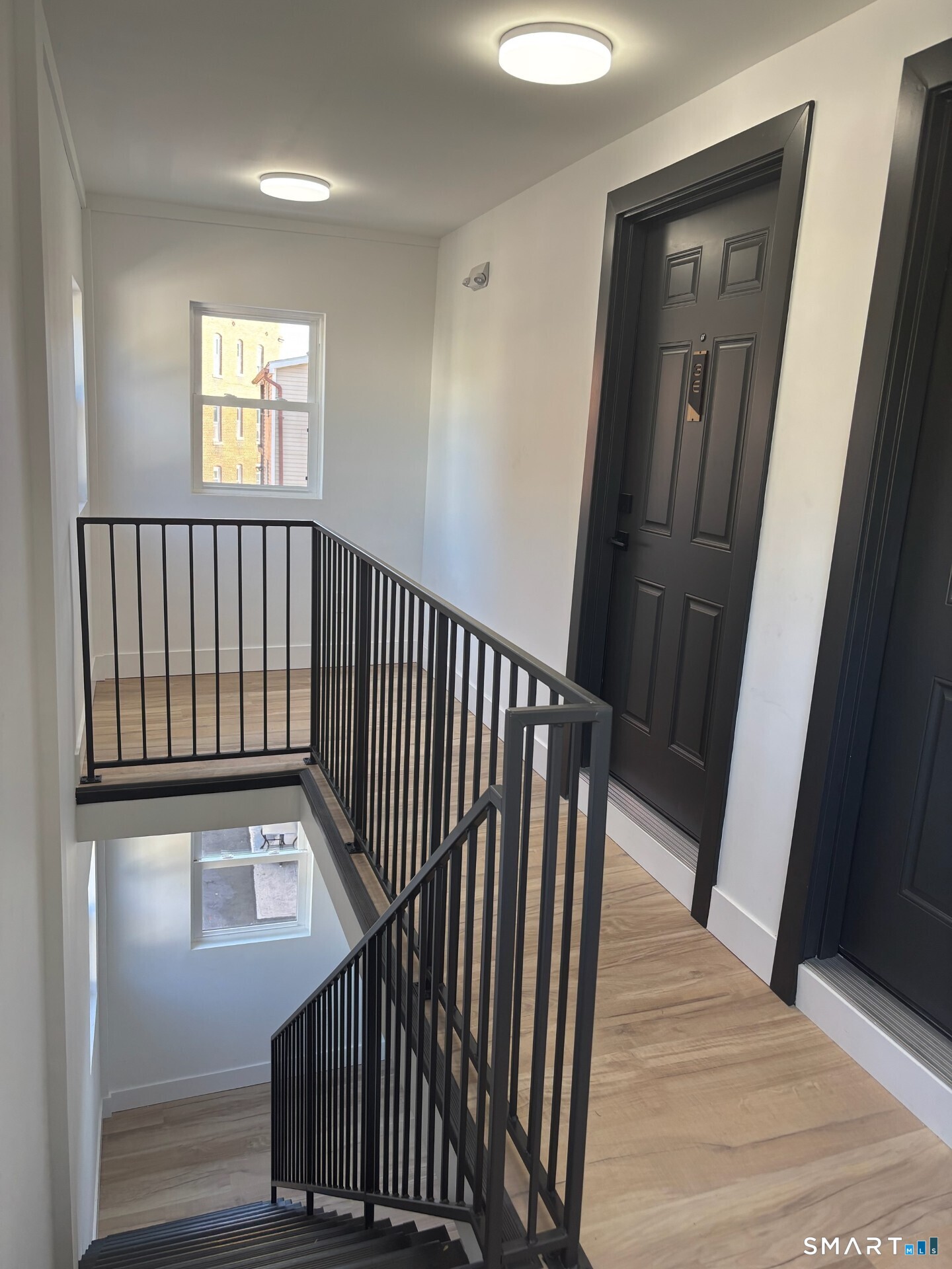 365 Broad Street, Unit 2E New Britain, CT 06053 - Photo 3 of 12 a view of a hallway with wooden floor and stairs