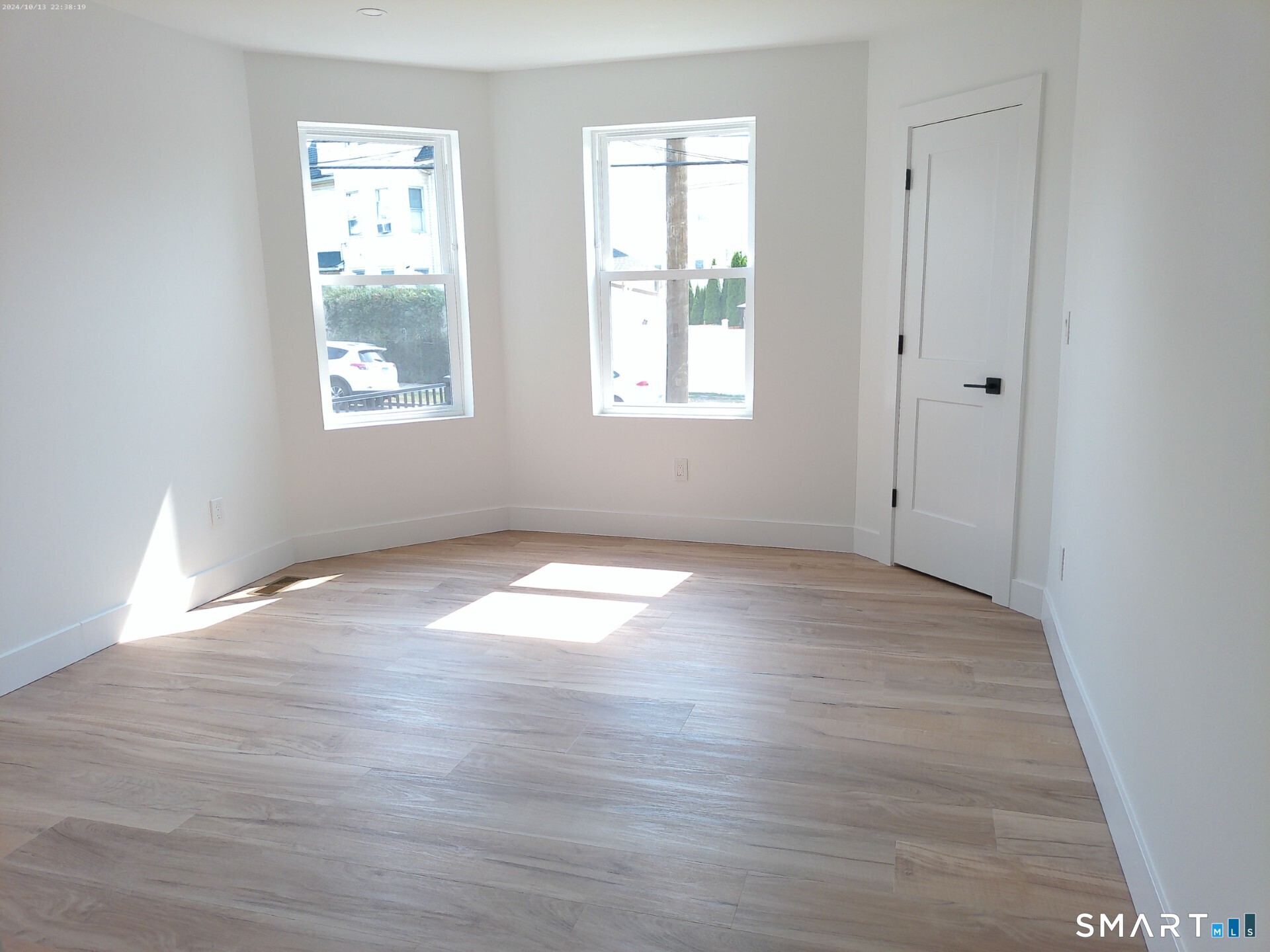 365 Broad Street, Unit 2E New Britain, CT 06053 - Photo 6 of 12 an empty room with wooden floor and windows