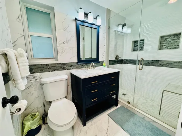 a bathroom with a toilet a sink and mirror