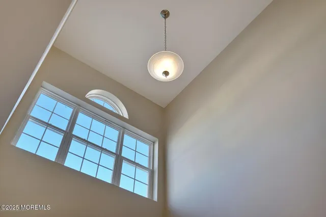 a view of staircase with railing and a chandelier