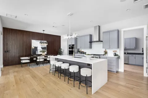 a kitchen with a dining table chairs and white cabinets
