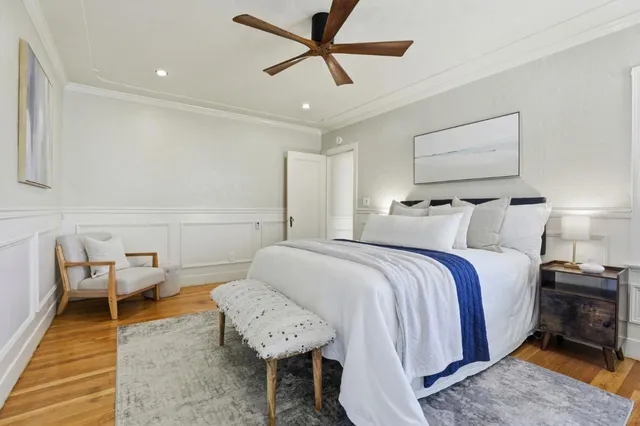 a spacious bedroom with a bed and wooden floor