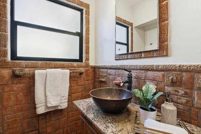 a bathroom with a granite countertop sink and a mirror