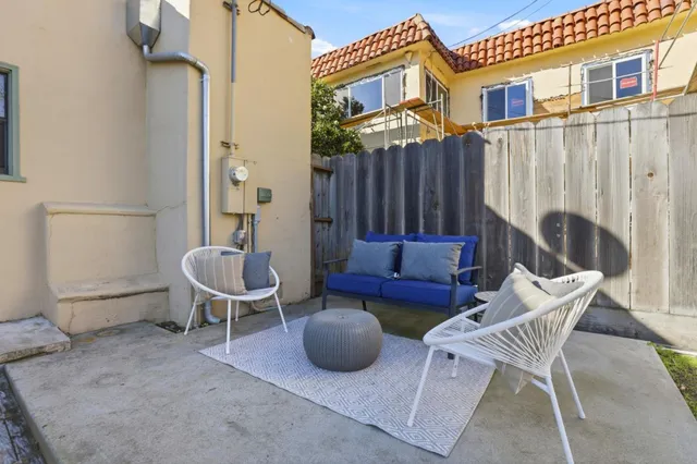 a view of a patio with chairs and a potted plant