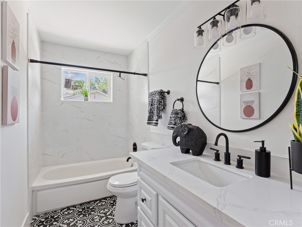 8419 18th Street Rancho Cucamonga, CA 91701 - Photo 23 of 28 a bathroom with a sink a toilet and a mirror