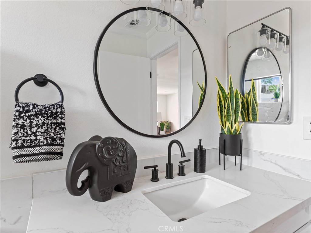 8419 18th Street Rancho Cucamonga, CA 91701 - Photo 24 of 28 a bathroom with a sink a mirror and a shower