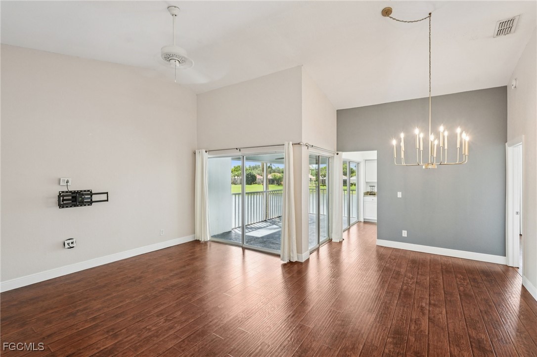 14983 Rivers Edge Court, Unit 230 Fort Myers, FL 33908 - Photo 14 of 47 a view of an empty room with wooden floor and a window