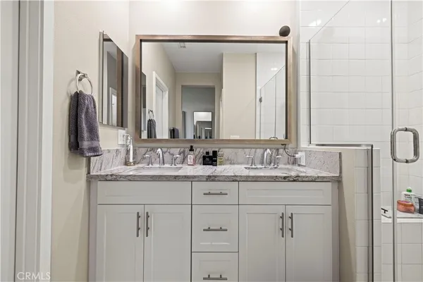 a bathroom with a granite countertop sink vanity and mirror