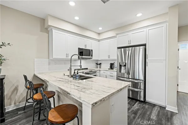 a kitchen that has a sink cabinets and wooden floor