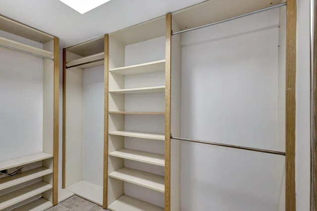 a view of walk in closet with empty racks