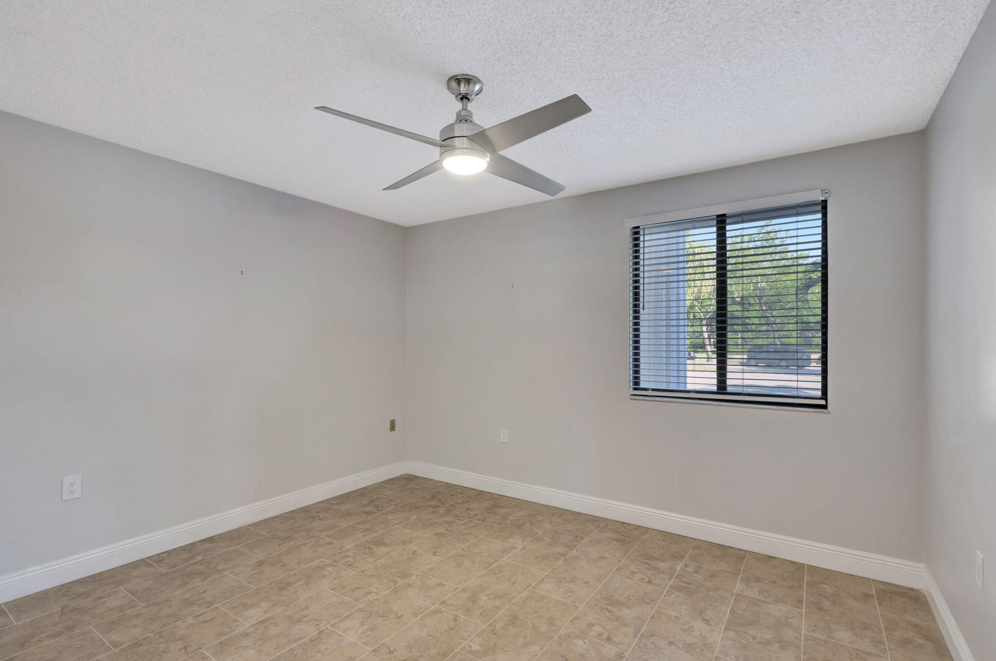 2741 Village Boulevard, Unit 104 West Palm Beach, FL 33409 - Photo 18 of 37 an empty room with a window and a fan