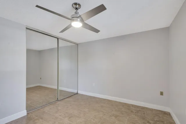 an empty room with a ceiling fan and a window