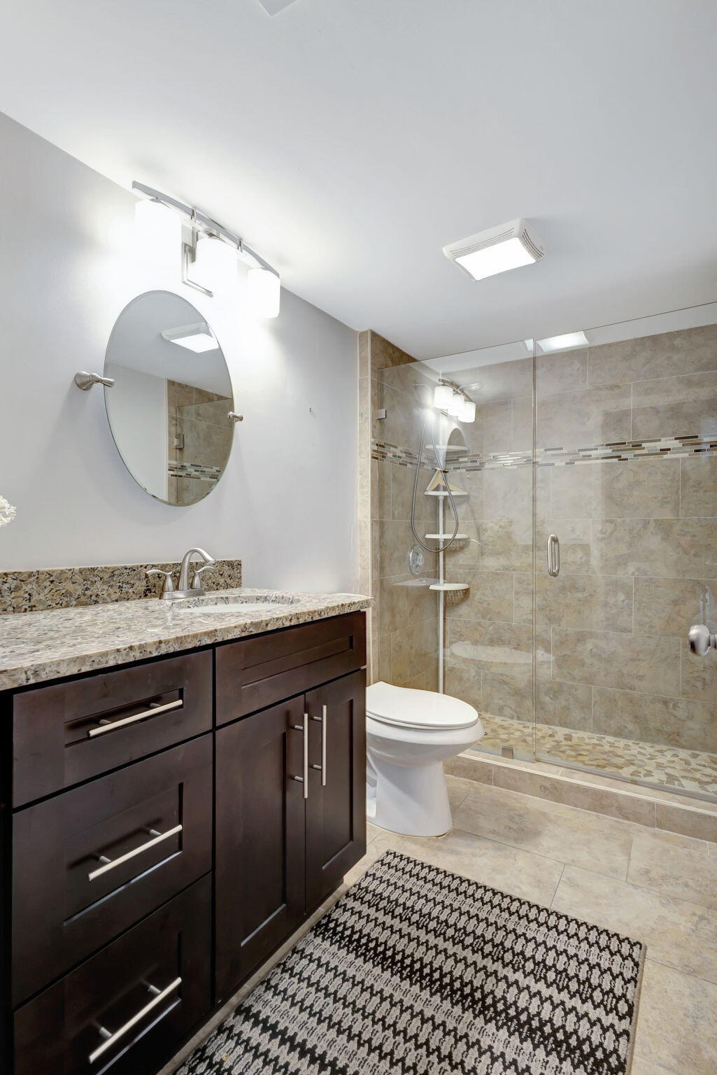 2741 Village Boulevard, Unit 104 West Palm Beach, FL 33409 - Photo 20 of 37 a bathroom with a toilet a sink and mirror