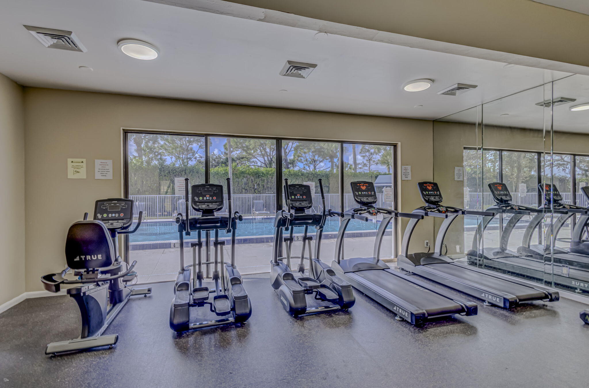 2741 Village Boulevard, Unit 104 West Palm Beach, FL 33409 - Photo 29 of 37 a room with gym equipment and floor to ceiling window