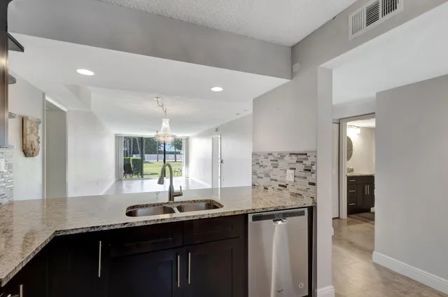a kitchen with stainless steel appliances a sink and a refrigerator
