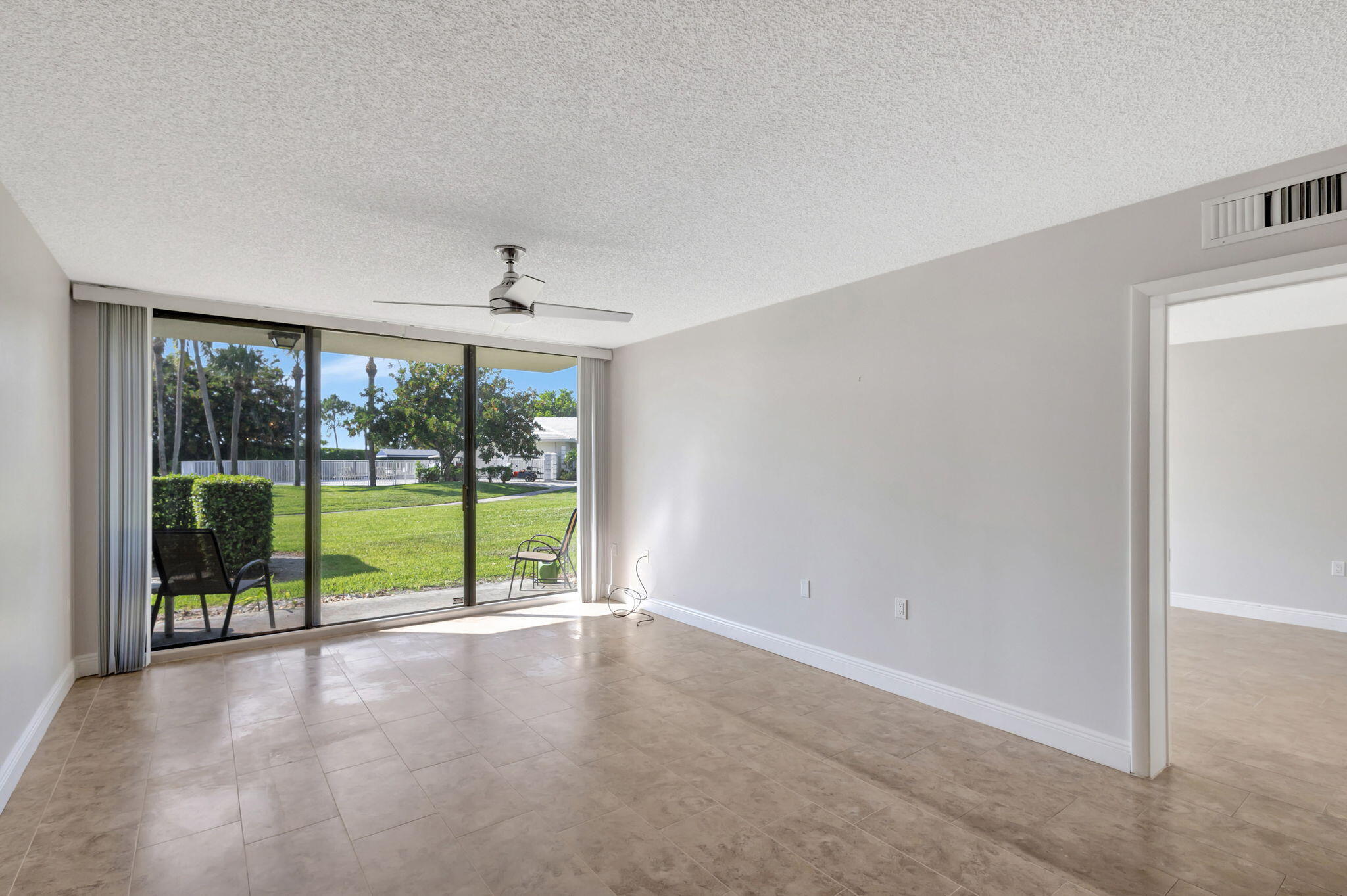 2741 Village Boulevard, Unit 104 West Palm Beach, FL 33409 - Photo 7 of 37 a view of an empty room with wooden floor and a window