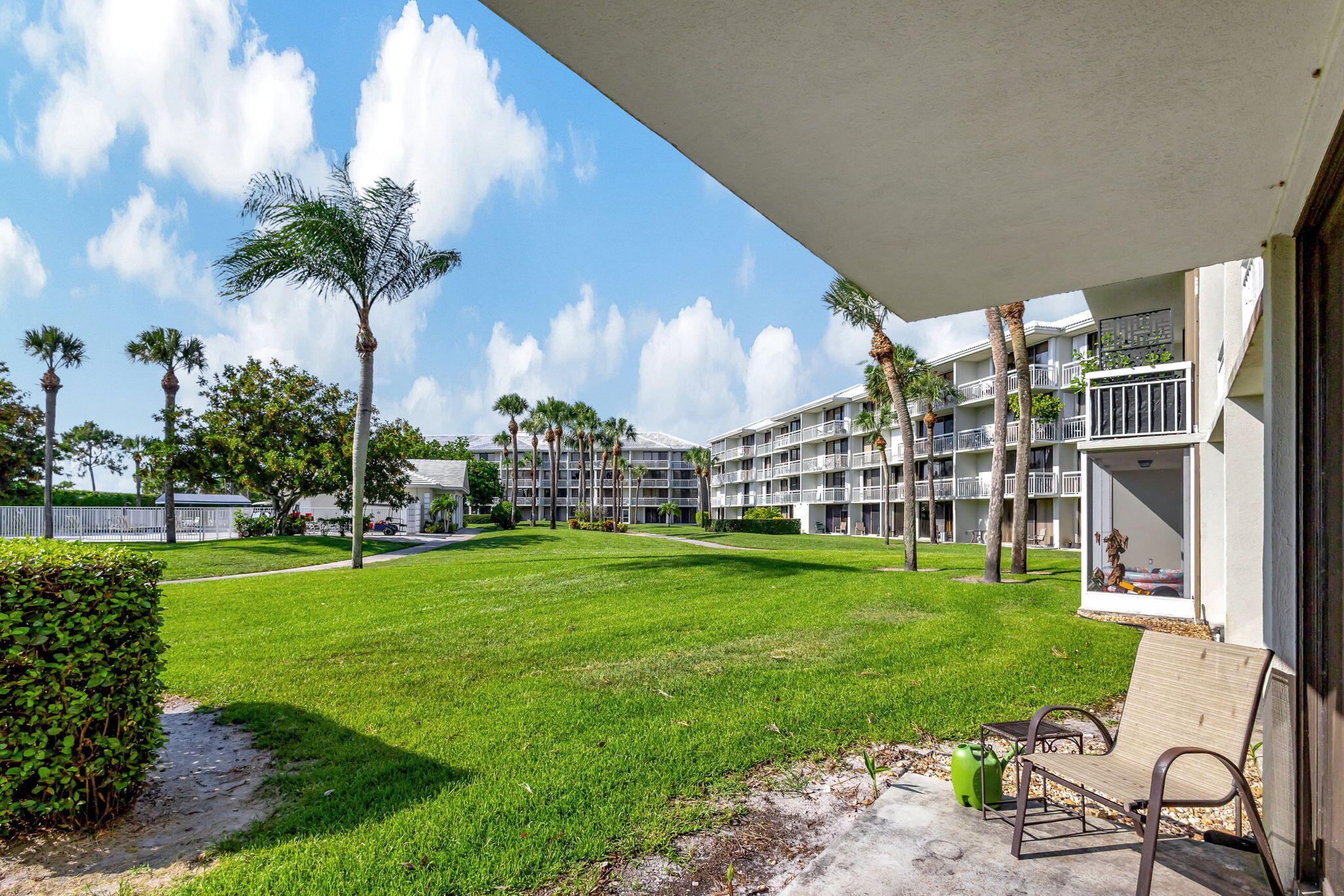 2741 Village Boulevard, Unit 104 West Palm Beach, FL 33409 - Photo 10 of 37 a view of a swimming pool with a garden and plants