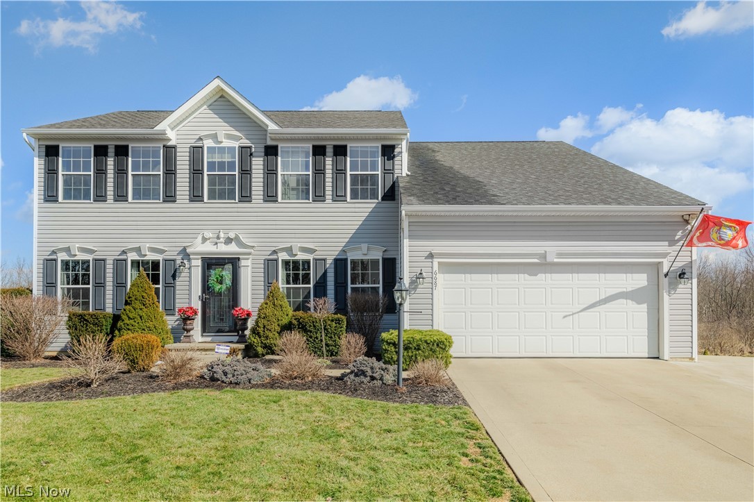 6687 List Street Northwest Canton, OH 44708 - Photo 1 of 21 Colonial-style house with driveway, an attached garage, a shingled roof, and a front lawn