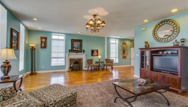 a living room with fireplace furniture and a rug