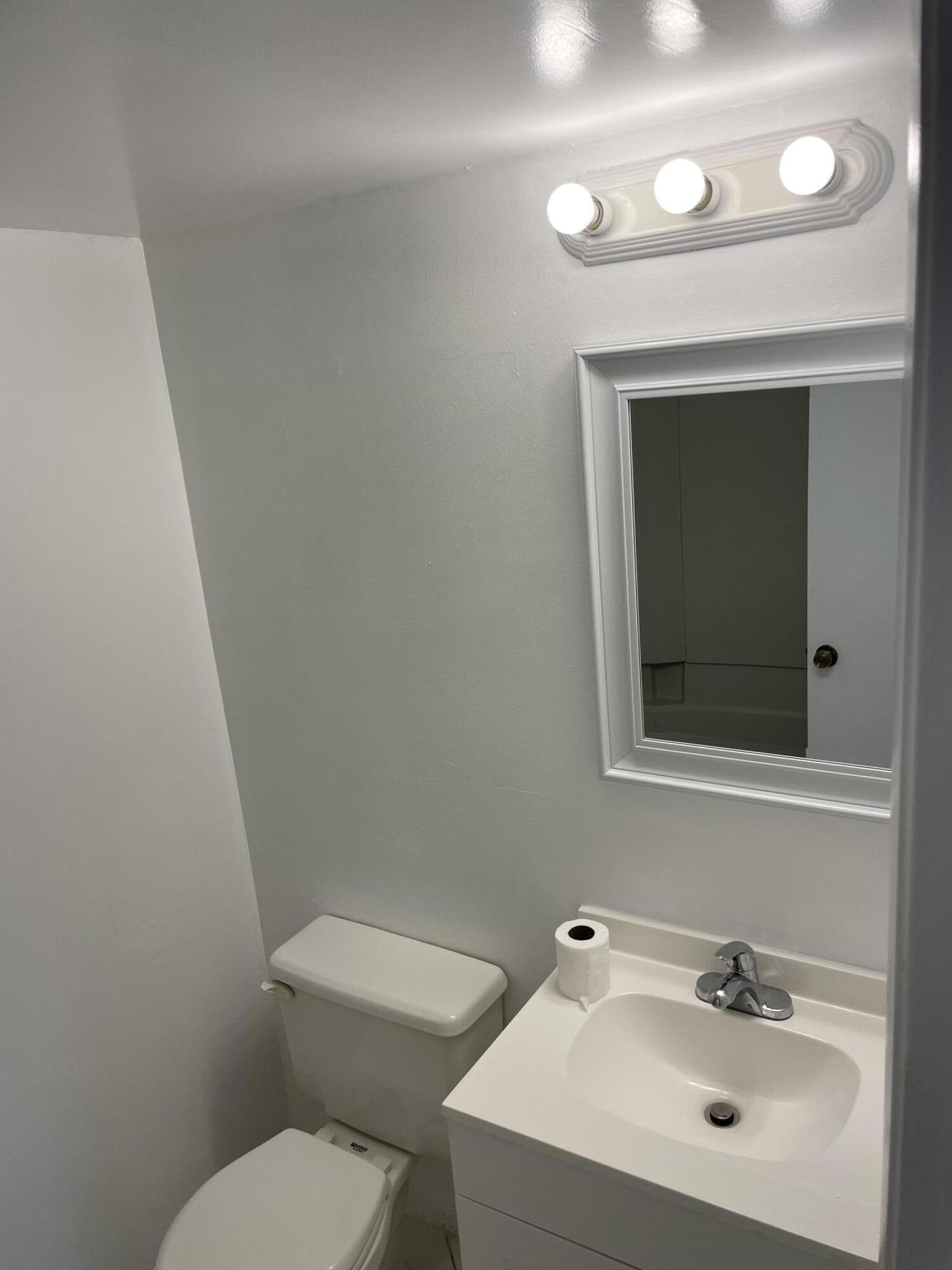 2771 Riverside Drive, Unit 113A Coral Springs, FL 33065 - Photo 3 of 8 a bathroom with a toilet sink and mirror