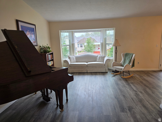 1263 Grayson Court Sandy, UT 84094 - Photo 3 of 26 Spacious living area featuring LVP flooring, a large bay window, and neutral wall tones