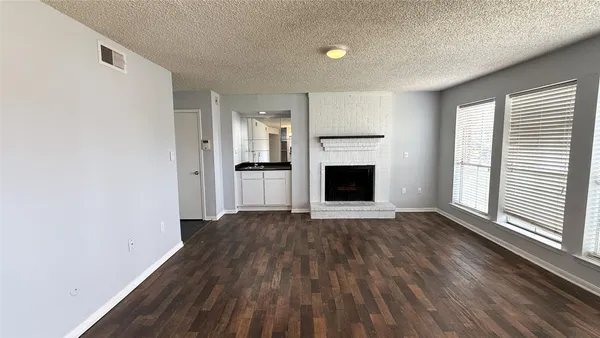 a view of empty room with wooden floor and fireplace