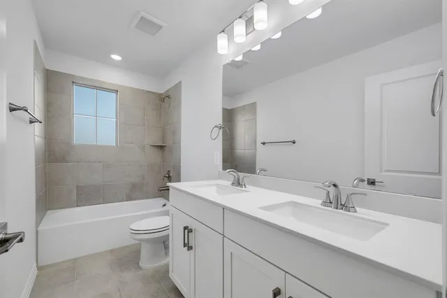 a bathroom with a sink a toilet and a large mirror