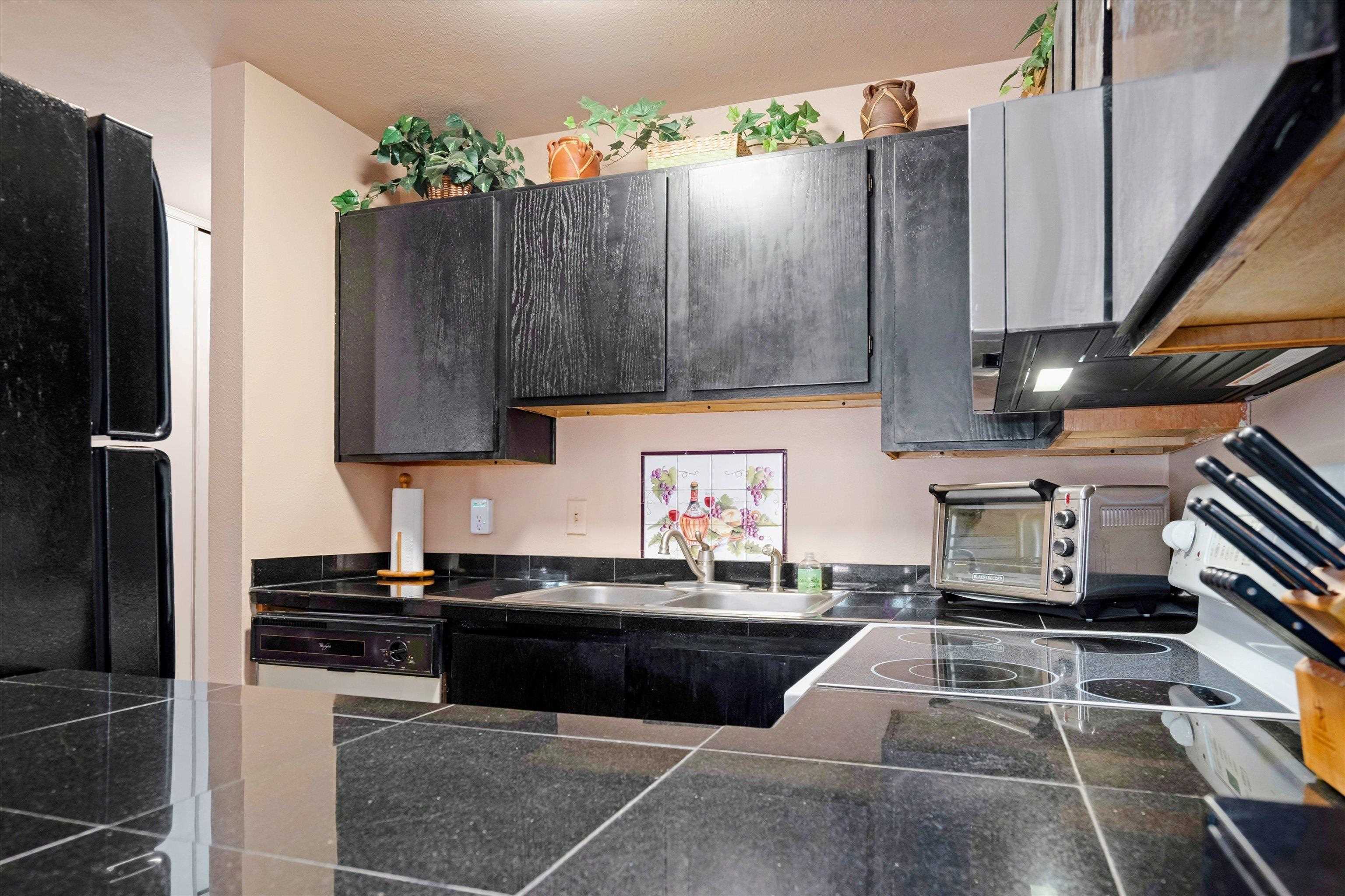 3740 Lower Honoapiilani Road, Unit C102 Lahaina, HI 96761 - Photo 11 of 50 a kitchen with granite countertop a sink stove and cabinets