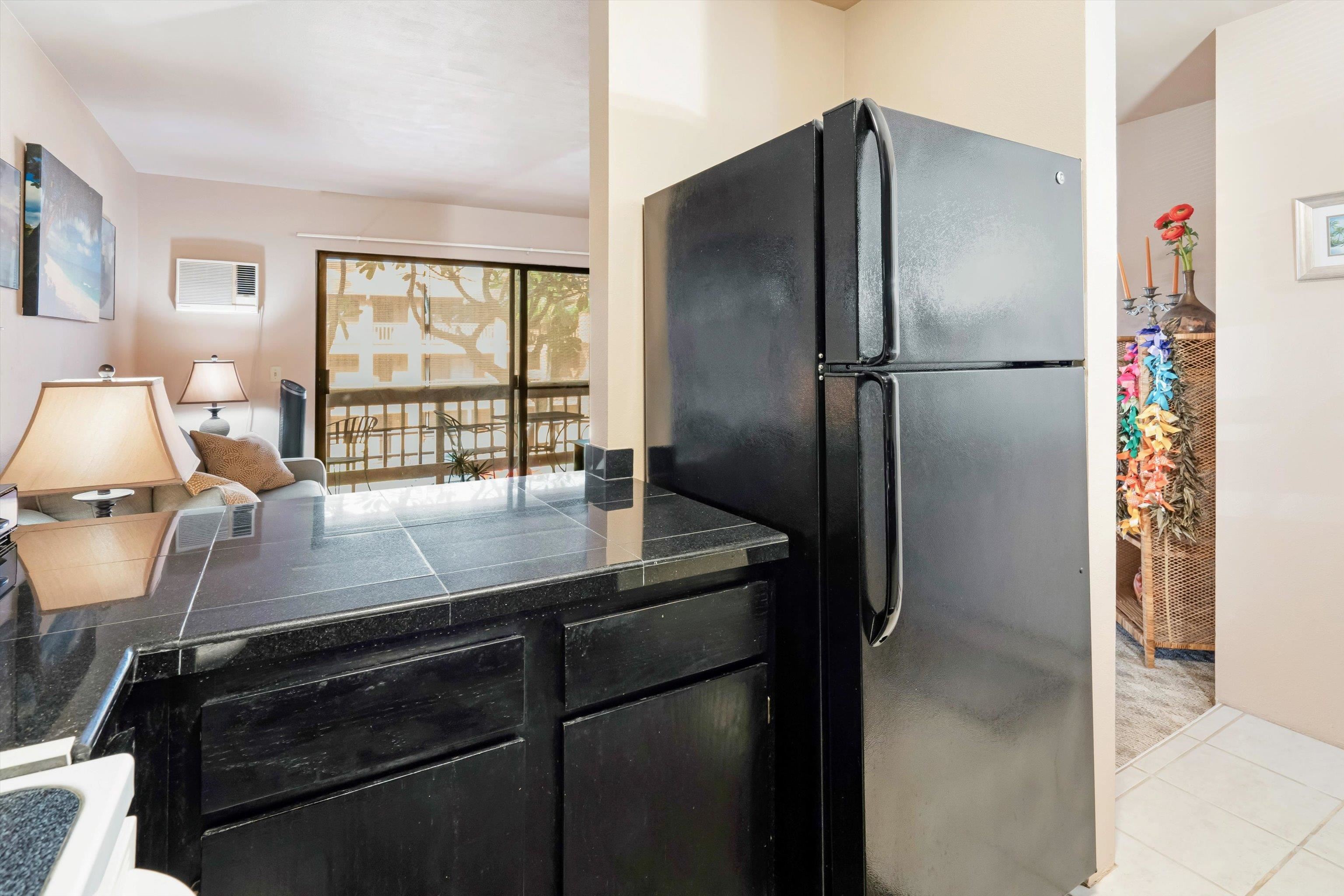 3740 Lower Honoapiilani Road, Unit C102 Lahaina, HI 96761 - Photo 14 of 50 a kitchen with kitchen island a counter top space and a refrigerator