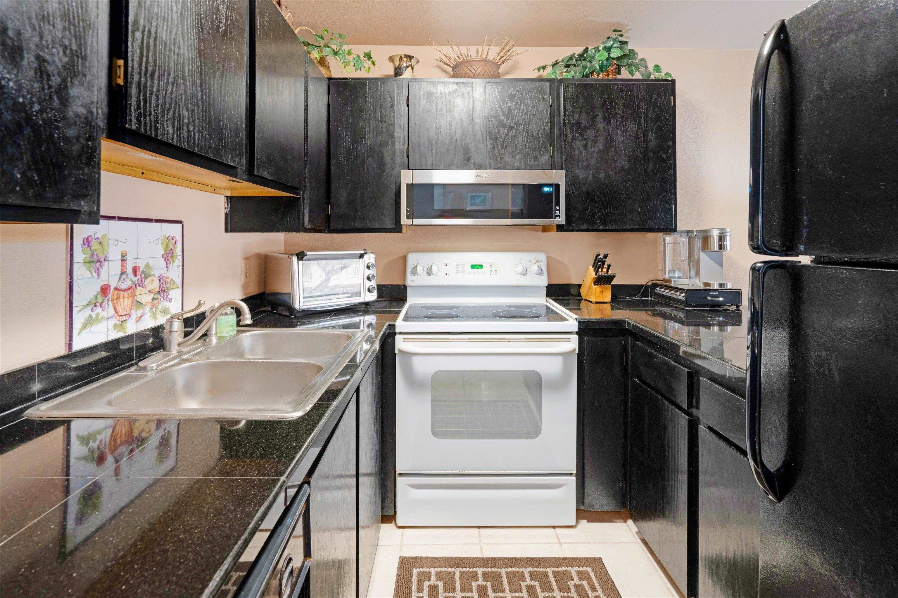 3740 Lower Honoapiilani Road, Unit C102 Lahaina, HI 96761 - Photo 15 of 50 a kitchen with stainless steel appliances granite countertop a sink stove and refrigerator