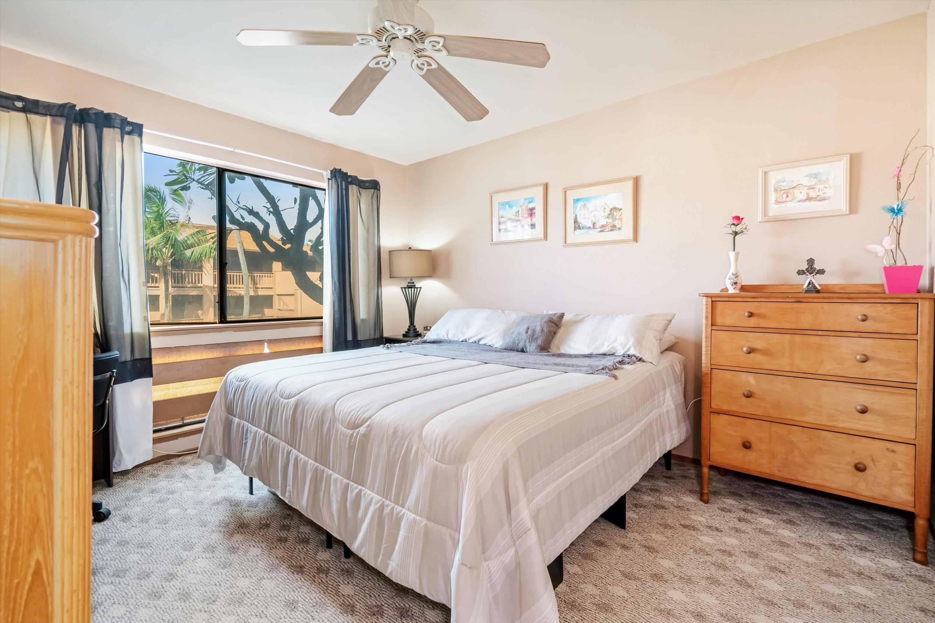 3740 Lower Honoapiilani Road, Unit C102 Lahaina, HI 96761 - Photo 2 of 50 a bedroom with a bed and a chandelier