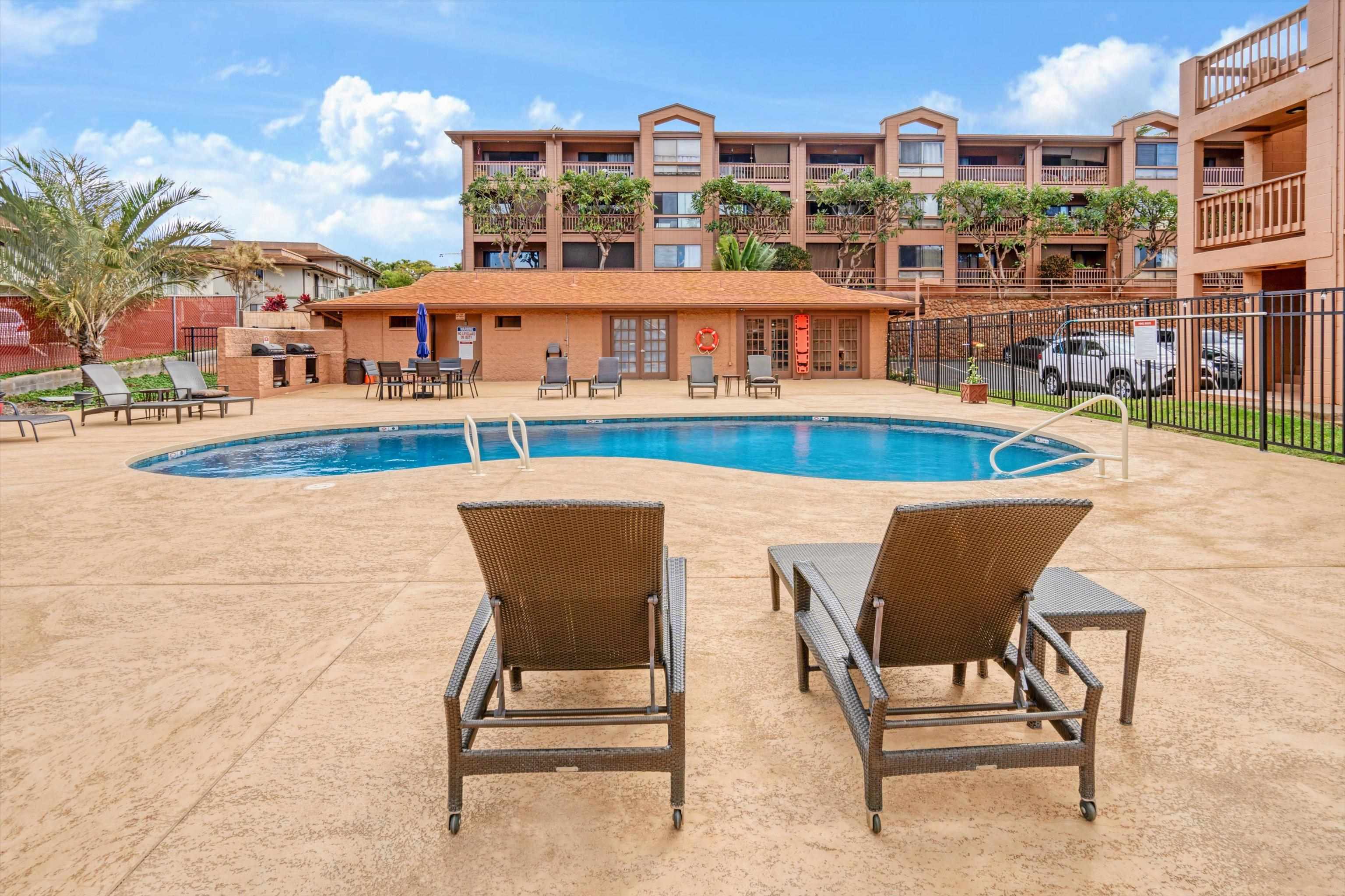 3740 Lower Honoapiilani Road, Unit C102 Lahaina, HI 96761 - Photo 34 of 50 a view of a swimming pool with outdoor seating and buildings in the background