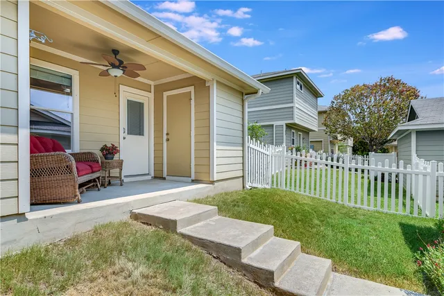 a view of a house with a patio and a yard