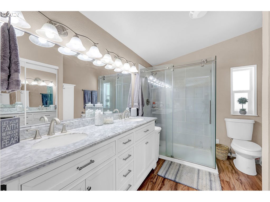 35235 Row River Road Cottage Grove, OR 97424 - Photo 13 of 28 a bathroom with a granite countertop sink a toilet a mirror and shower