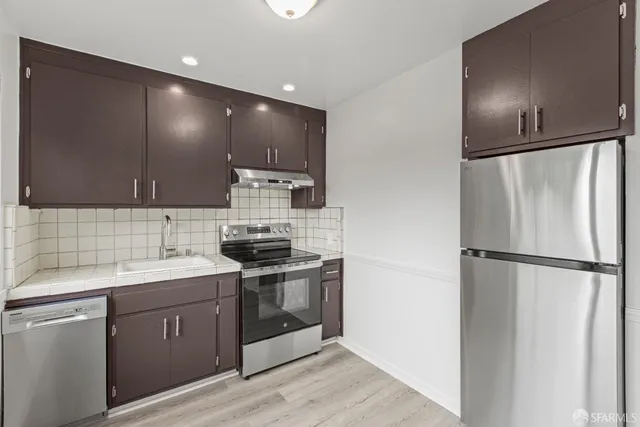 a kitchen with a sink stainless steel appliances and cabinets