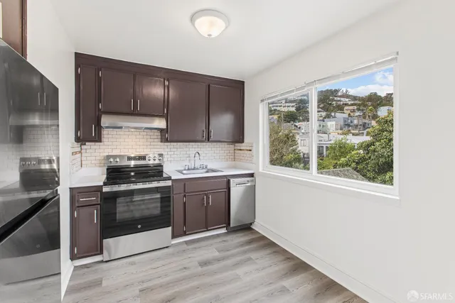 a kitchen with stainless steel appliances granite countertop a stove a sink and a microwave