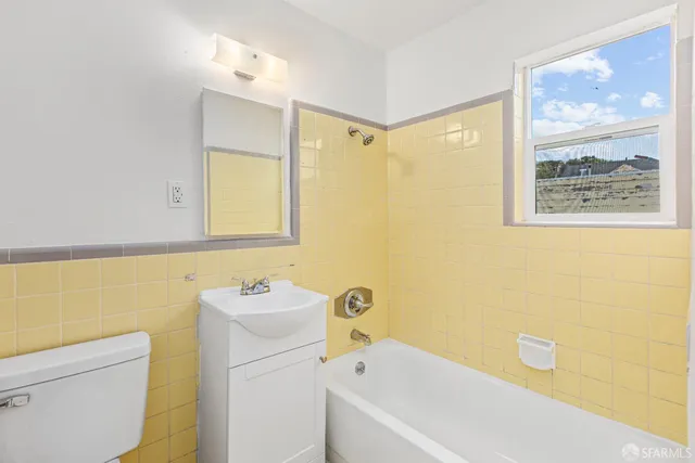 a bathroom with a tub sink and mirror