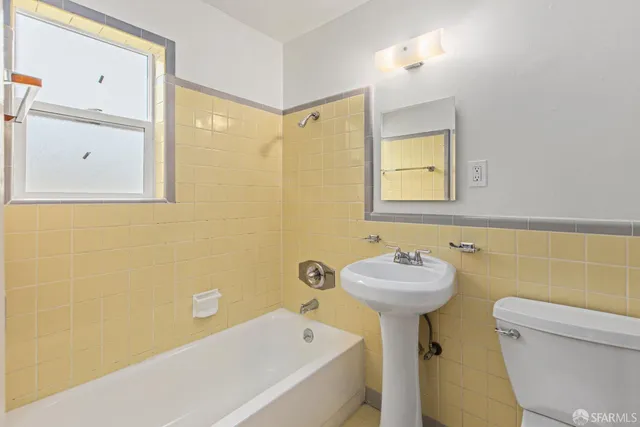 a bathroom with a sink mirror and toilet